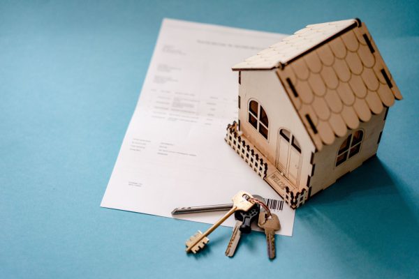 keys and house with legal paperwork in the background